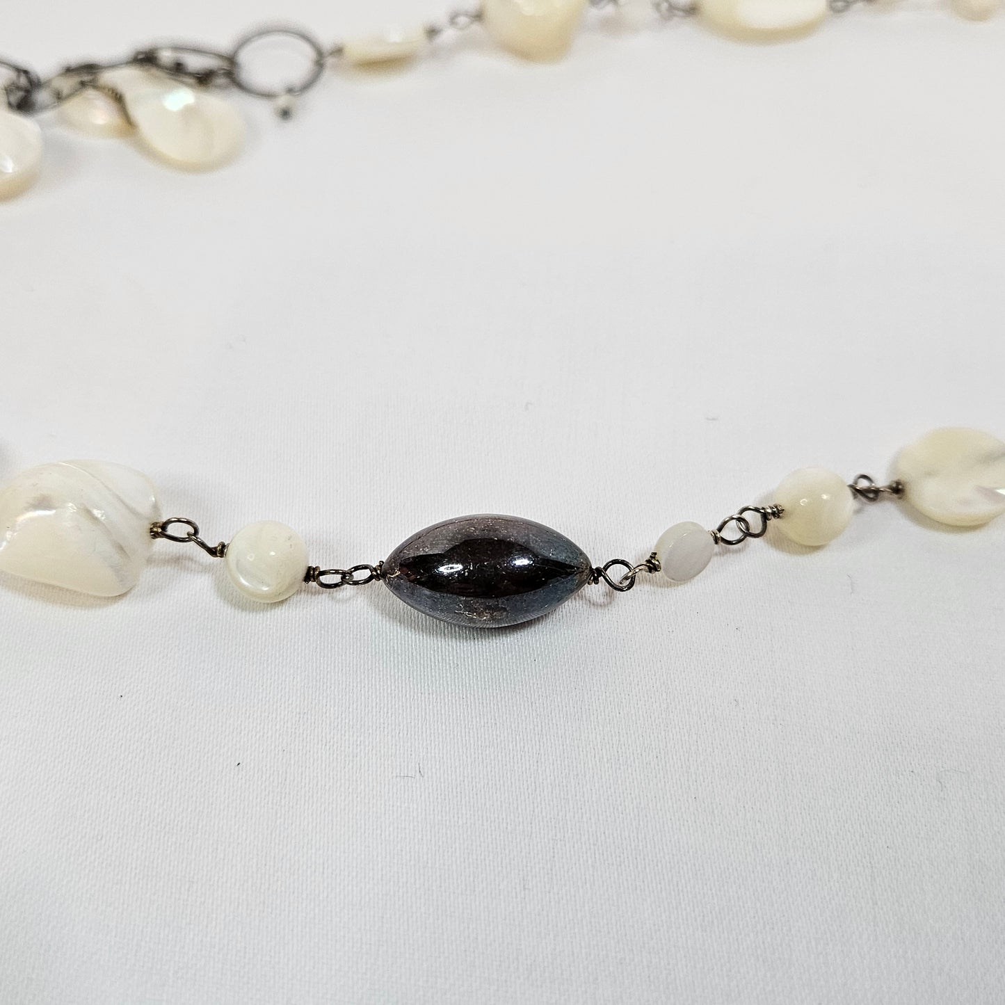 Asymmetric long necklace with mother of pearl beads and silver hoops and chain