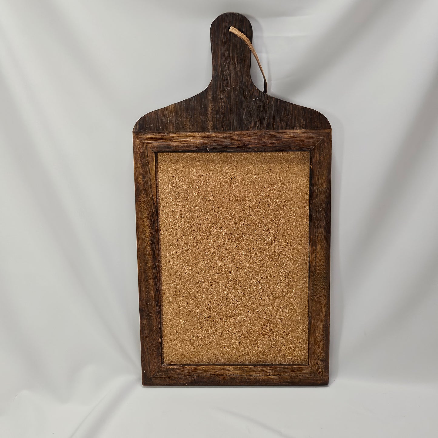 Primitive wooden corkboard with leather hanging strap, 17.25 x 9 "