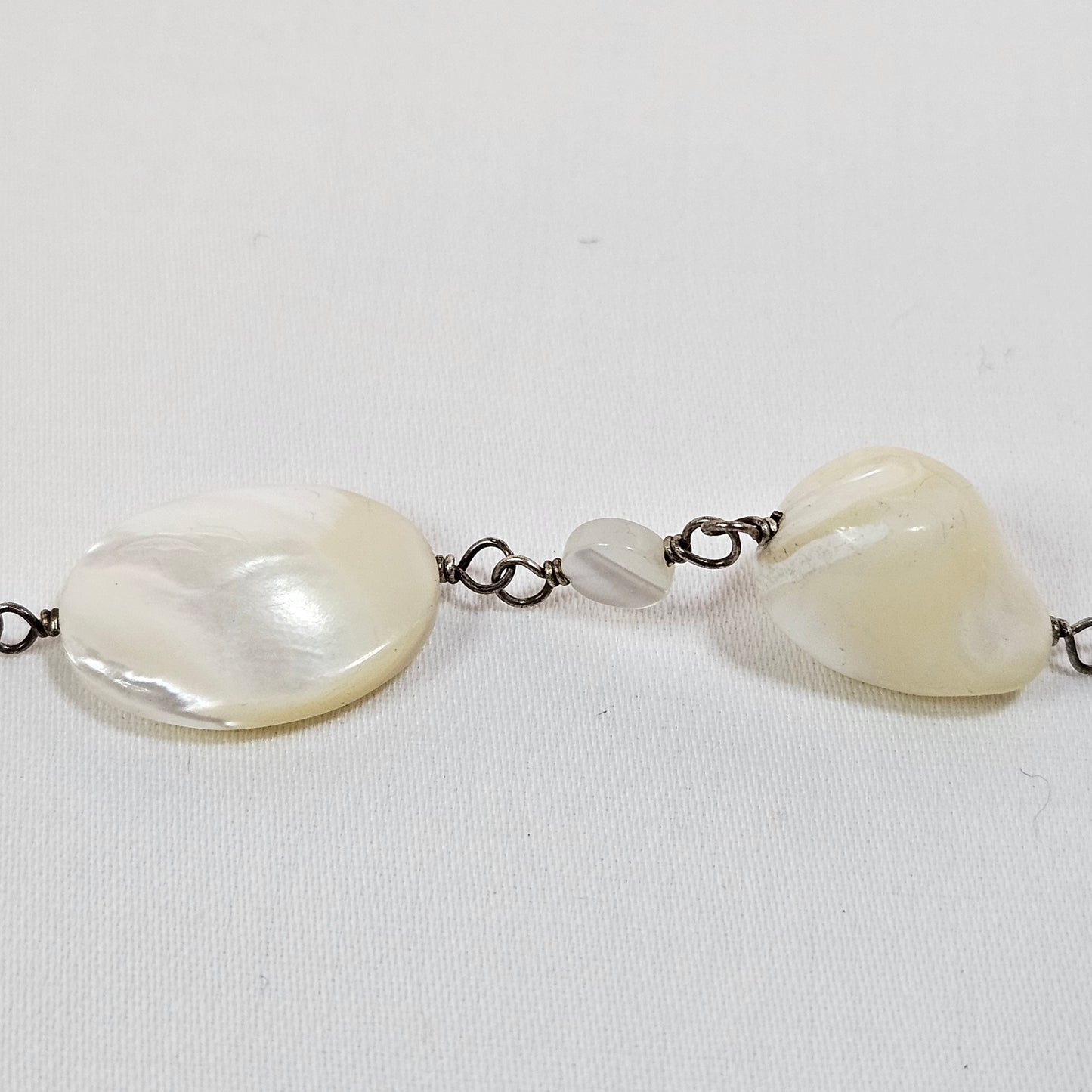 Asymmetric long necklace with mother of pearl beads and silver hoops and chain