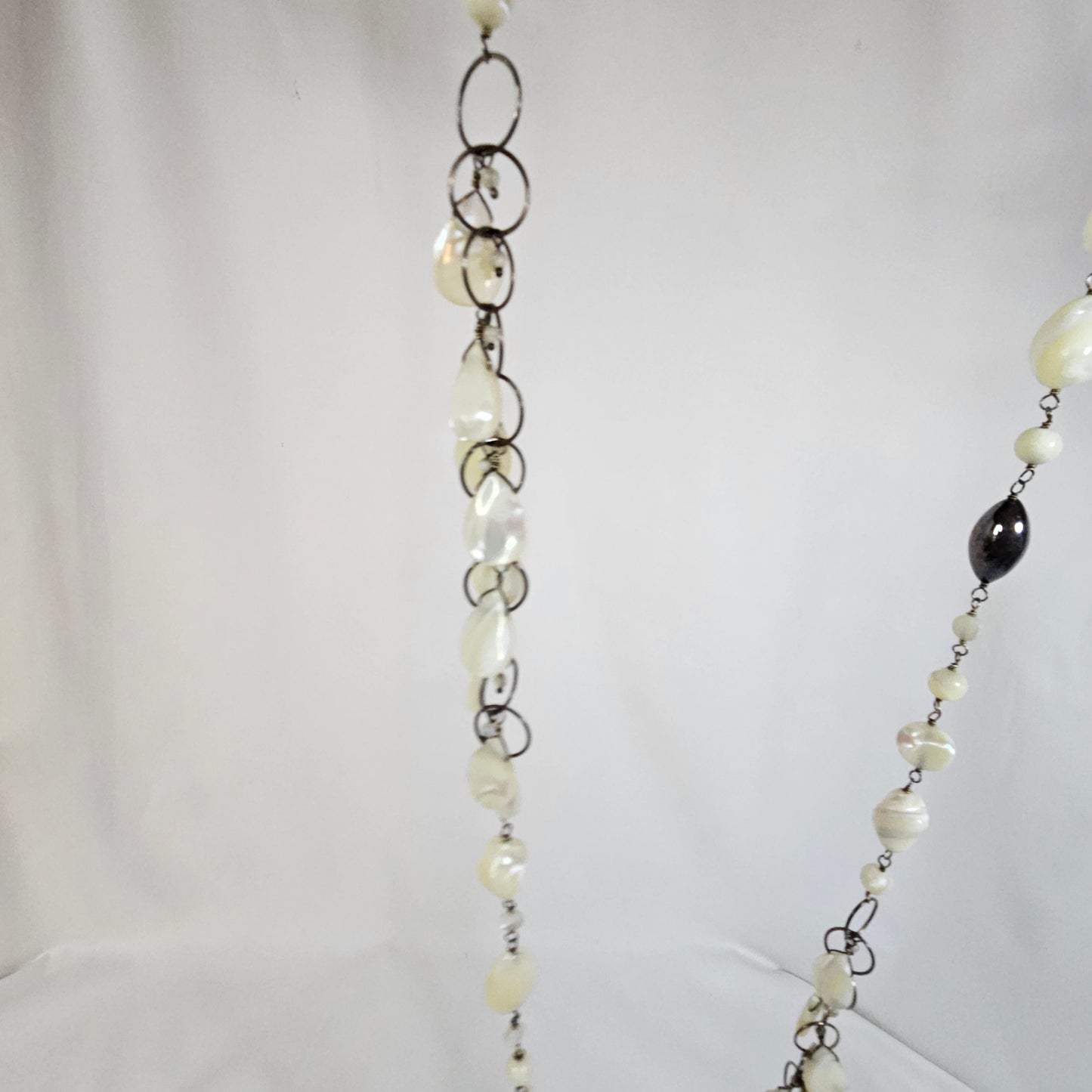 Asymmetric long necklace with mother of pearl beads and silver hoops and chain