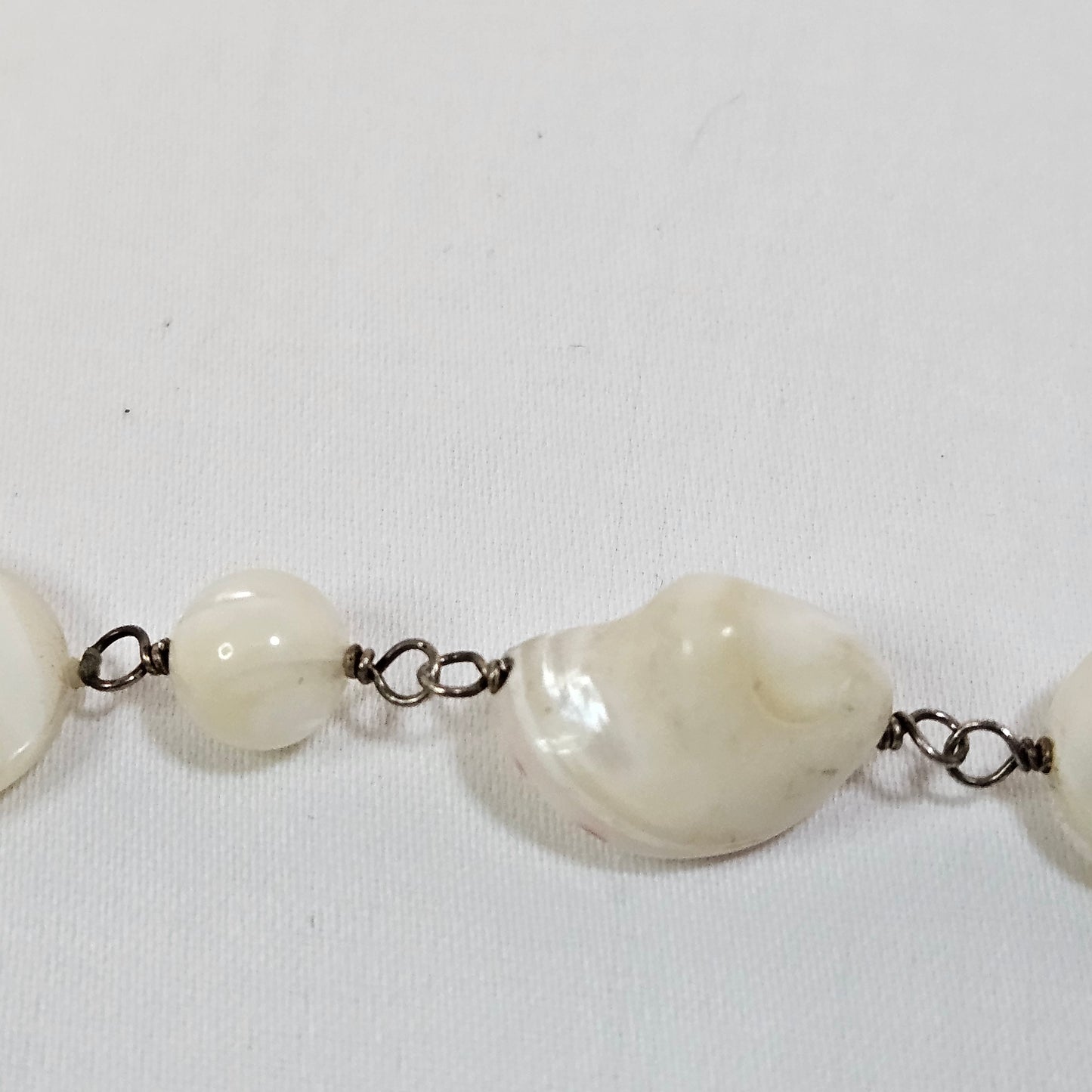 Asymmetric long necklace with mother of pearl beads and silver hoops and chain