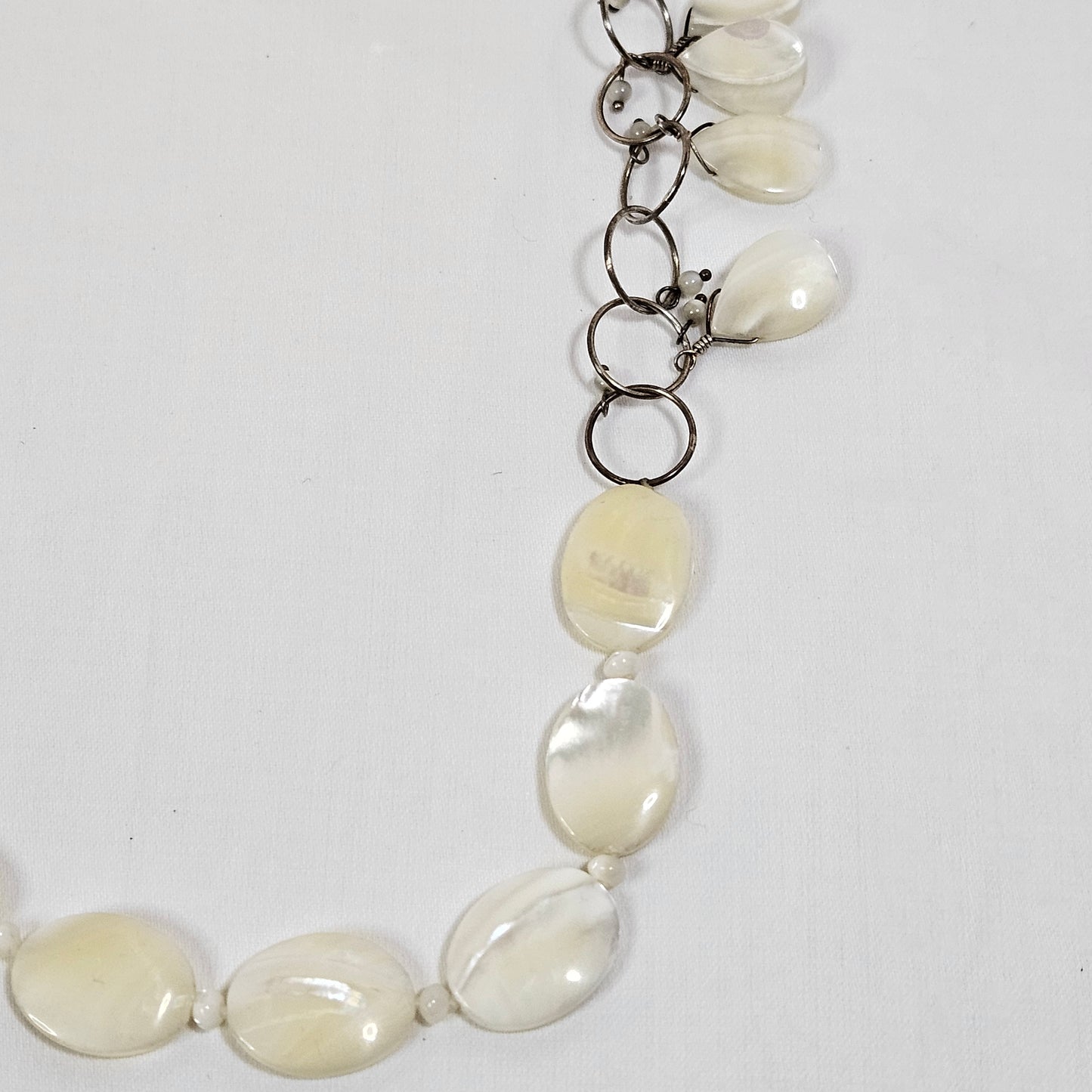 Asymmetric long necklace with mother of pearl beads and silver hoops and chain