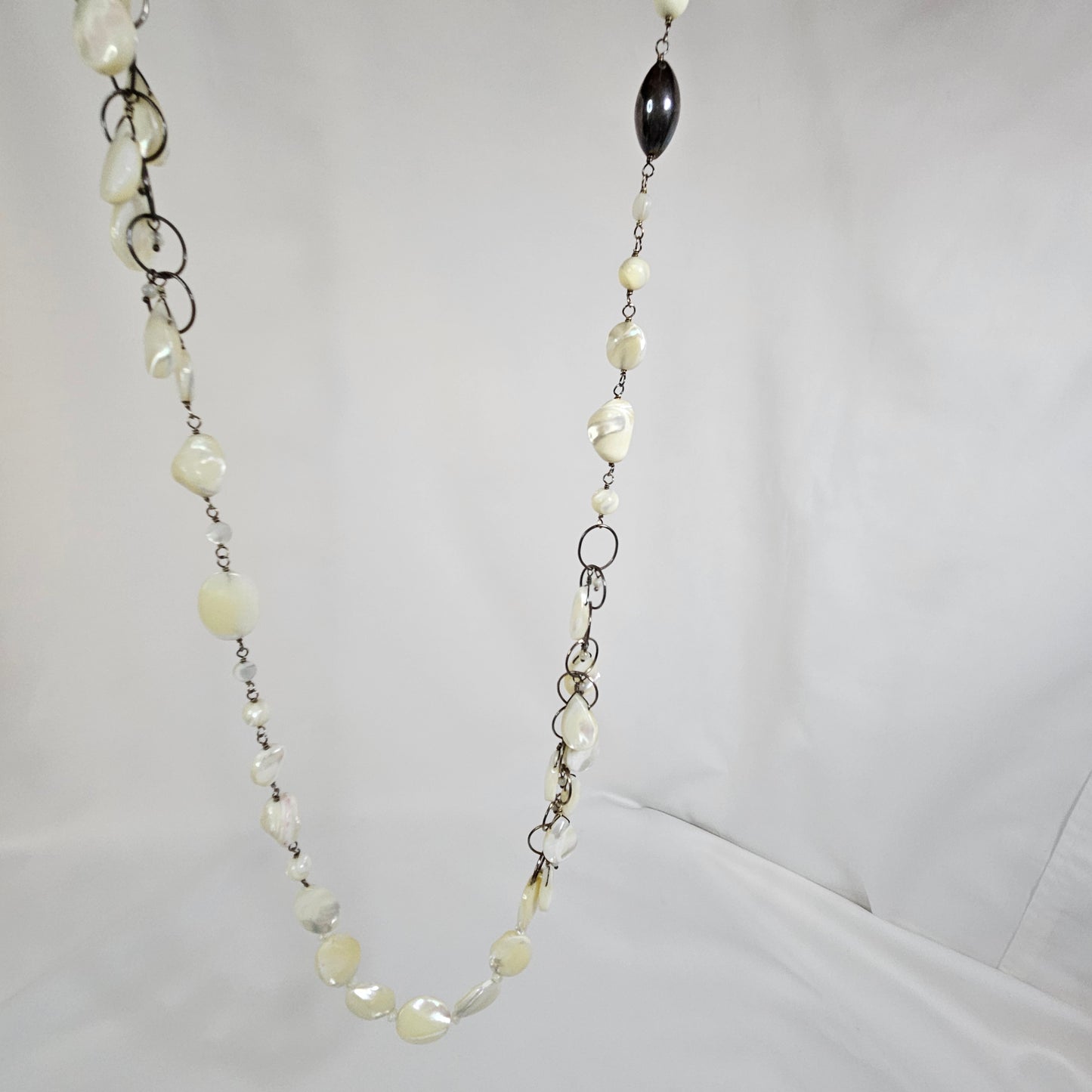 Asymmetric long necklace with mother of pearl beads and silver hoops and chain