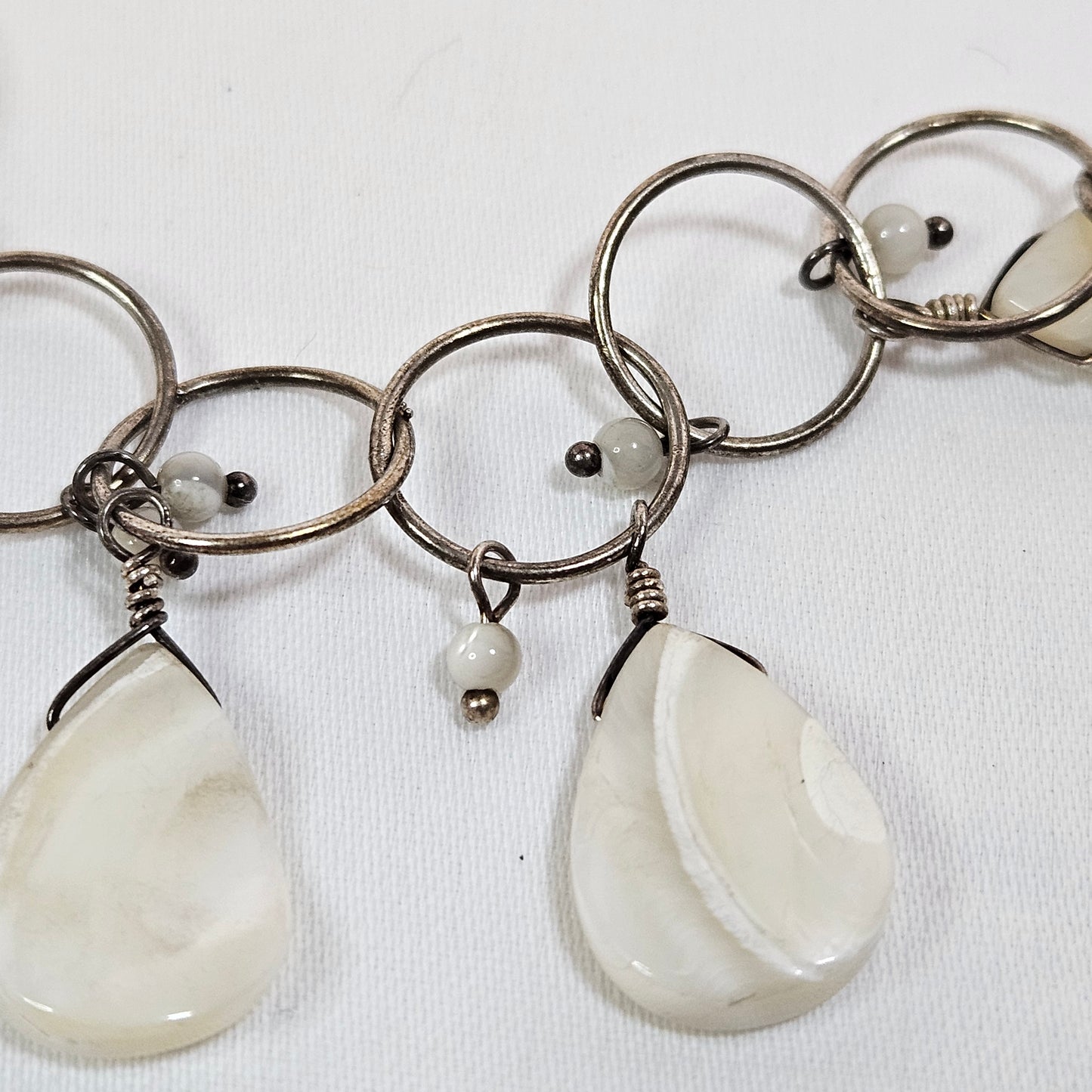 Asymmetric long necklace with mother of pearl beads and silver hoops and chain