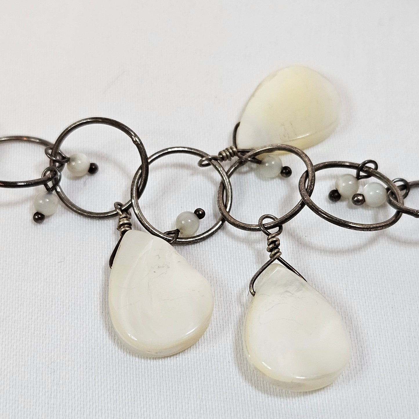 Asymmetric long necklace with mother of pearl beads and silver hoops and chain