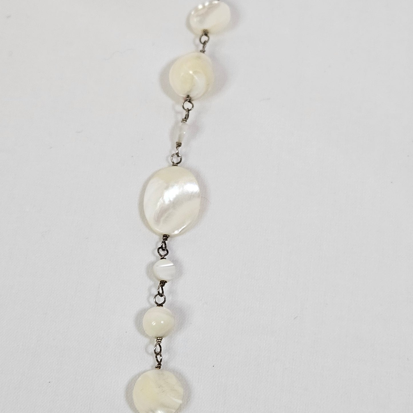 Asymmetric long necklace with mother of pearl beads and silver hoops and chain