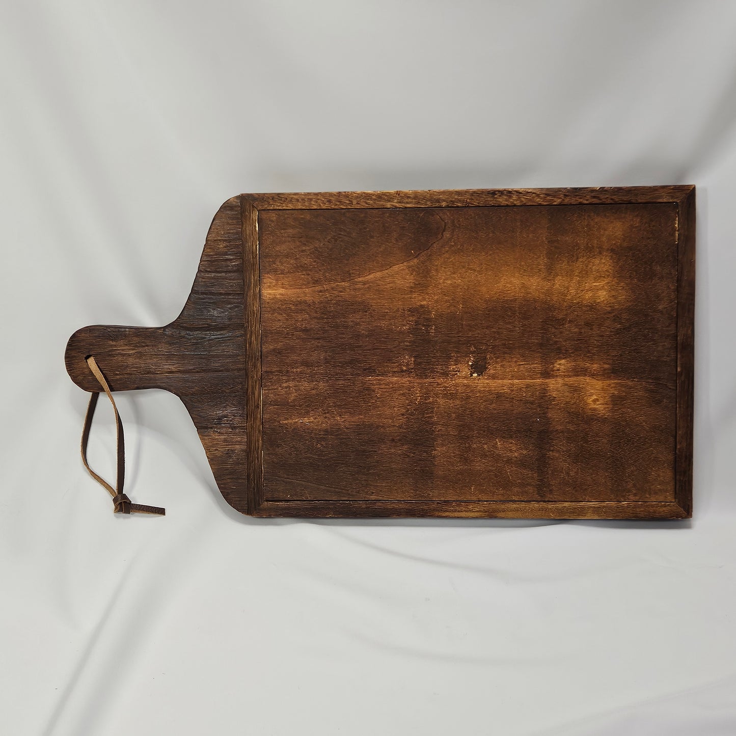 Primitive wooden corkboard with leather hanging strap, 17.25 x 9 "