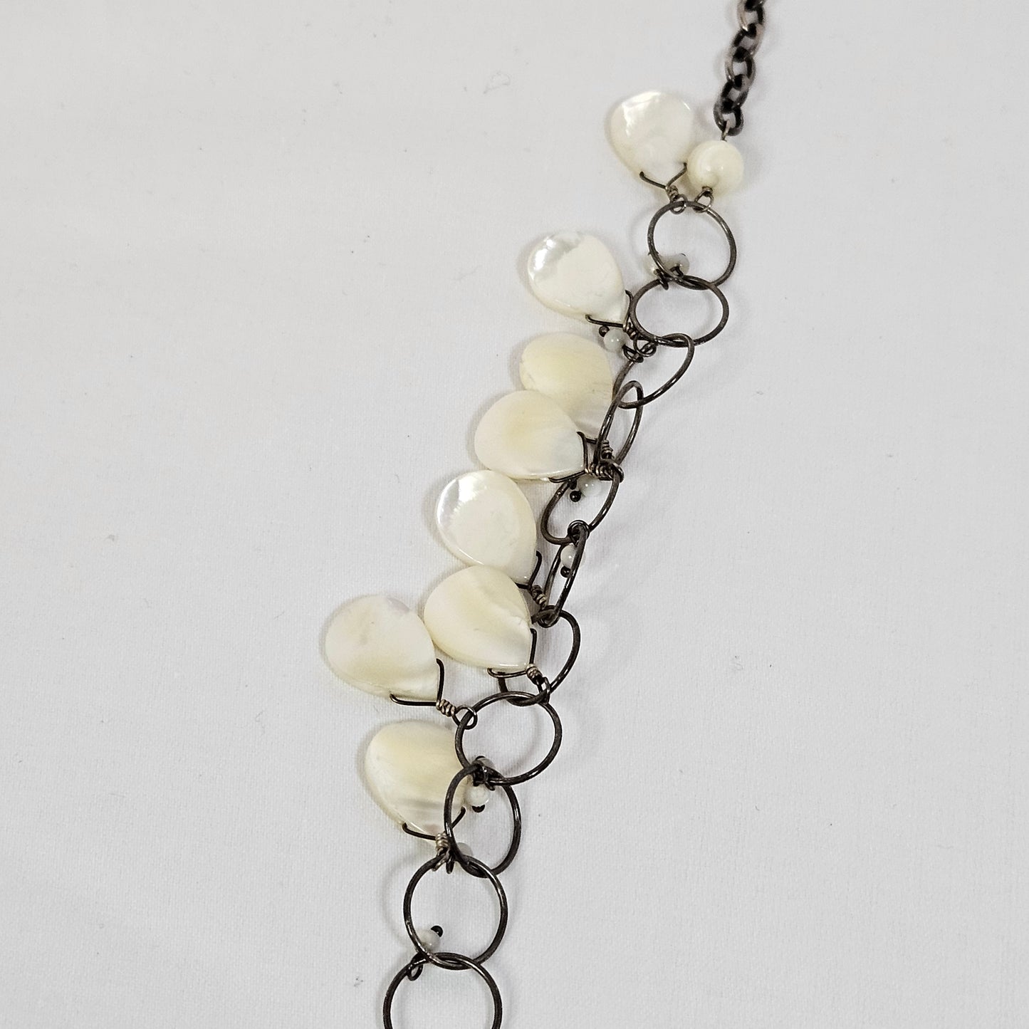 Asymmetric long necklace with mother of pearl beads and silver hoops and chain